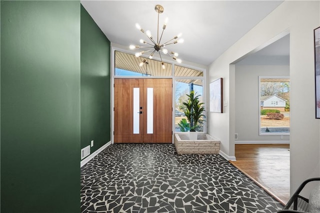 foyer with french doors, lofted ceiling, hardwood / wood-style flooring, and a notable chandelier