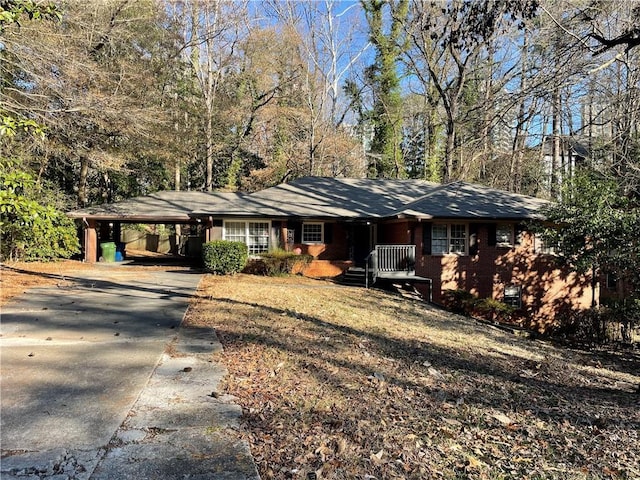 ranch-style house with an attached carport, brick siding, and driveway