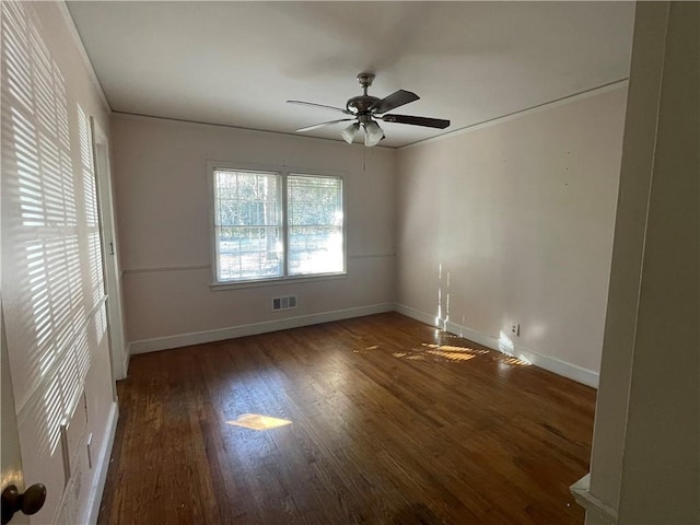 spare room with visible vents, crown molding, baseboards, wood finished floors, and a ceiling fan