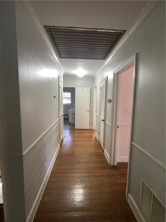 corridor with dark wood finished floors, visible vents, and crown molding