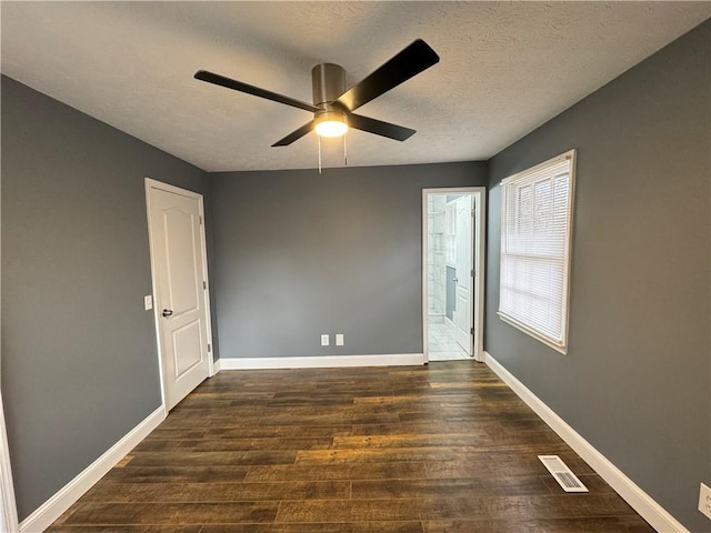 unfurnished room featuring ceiling fan, dark wood-type flooring, and a textured ceiling