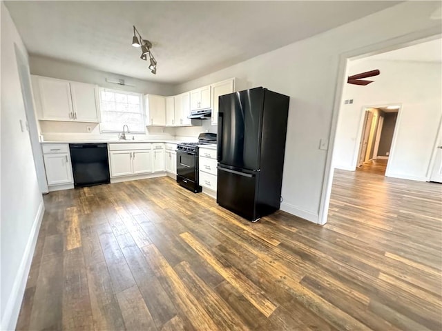 kitchen featuring sink, rail lighting, dark hardwood / wood-style floors, black appliances, and white cabinets