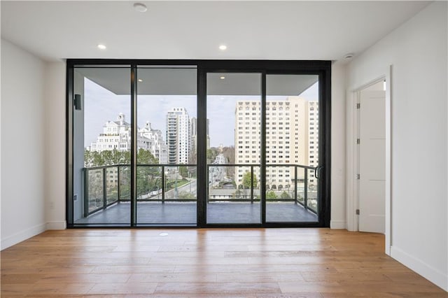 2425 Peachtree Rd NE Unit 903, Atlanta, GA 30305 - unfurnished room with a wall of windows, healthy amount of natural light, wood finished floors, a city view, and recessed lighting