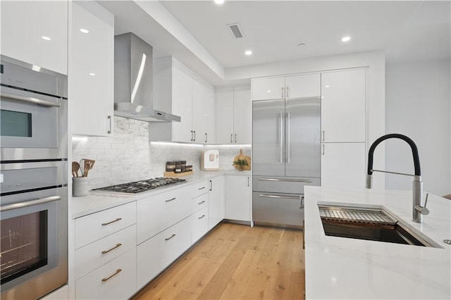 2425 Peachtree Rd NE Unit 903, Atlanta, GA 30305 - kitchen with appliances with stainless steel finishes, modern cabinets, wall chimney exhaust hood, white cabinetry, and recessed lighting
