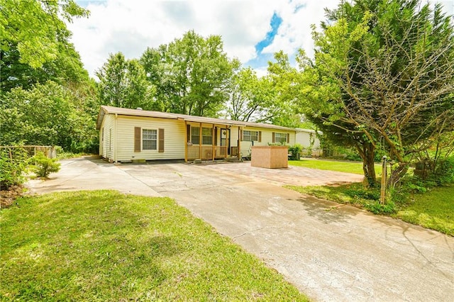 ranch-style home with concrete driveway and a front lawn