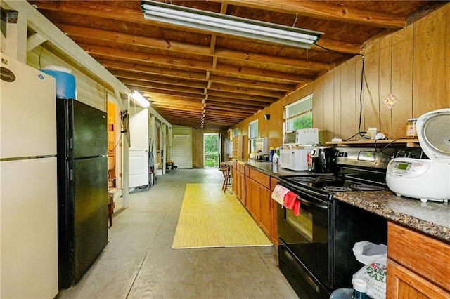 kitchen with black appliances, brown cabinets, dark countertops, concrete floors, and beam ceiling