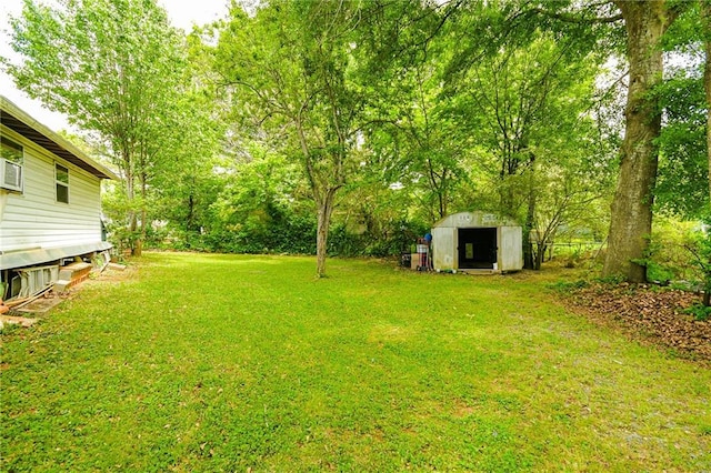 view of green lawn featuring a shed and an outbuilding