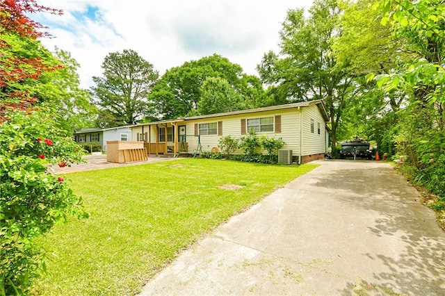 manufactured / mobile home with driveway, a front lawn, and central AC