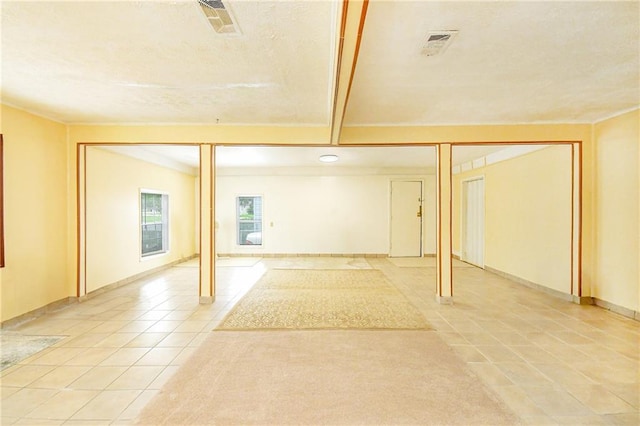 below grade area with light tile patterned flooring and a textured ceiling