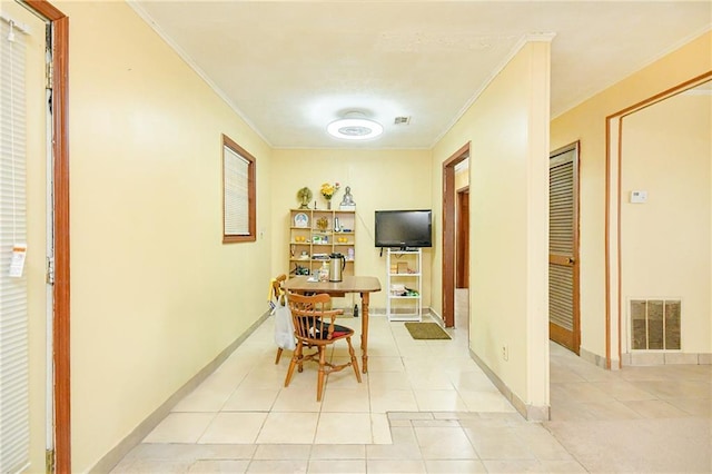 dining area featuring ornamental molding, light tile patterned floors, and baseboards