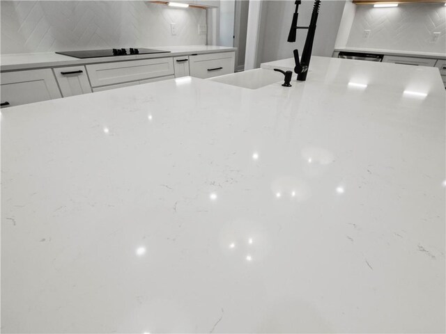2335 Azalea Dr, Loganville, GA 30052 - kitchen view of black electric stovetop, decorative backsplash, and light countertops