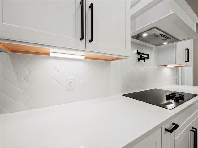 2335 Azalea Dr, Loganville, GA 30052 - kitchen with black electric cooktop, white cabinets, light countertops, ventilation hood, and backsplash