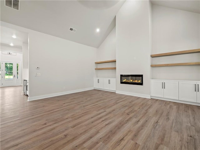 2335 Azalea Dr, Loganville, GA 30052 - unfurnished living room with light wood-style floors, high vaulted ceiling, recessed lighting, and a glass covered fireplace