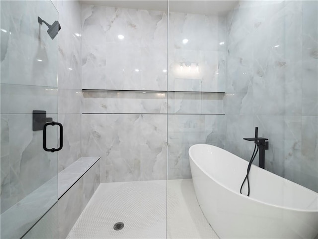 2335 Azalea Dr, Loganville, GA 30052 - bathroom featuring a shower stall, a freestanding bath, and tile walls