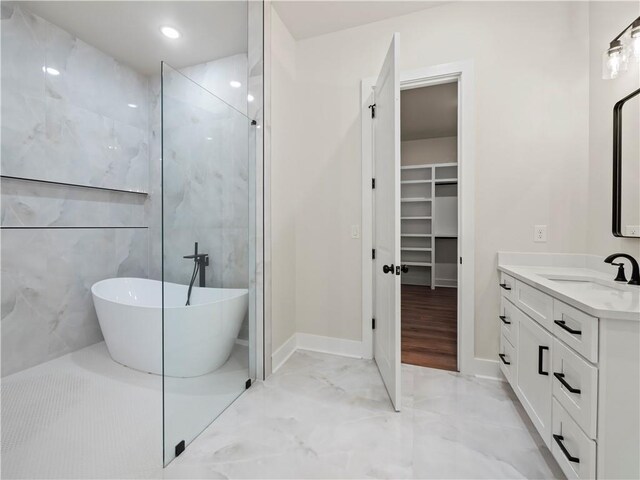 2335 Azalea Dr, Loganville, GA 30052 - full bathroom with marble tiled floors, vanity, a freestanding bath, a spacious closet, and a walk in shower