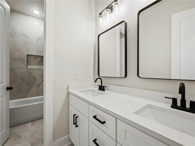 2335 Azalea Dr, Loganville, GA 30052 - bathroom with double vanity, marble look tile flooring, and washtub / shower combination