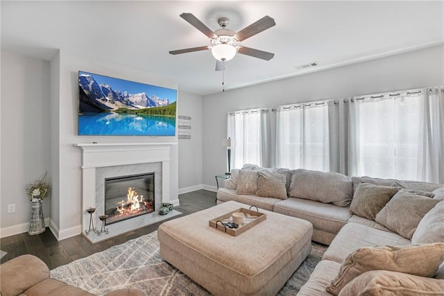 living area featuring visible vents, dark wood finished floors, baseboards, and a premium fireplace