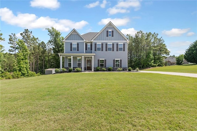 view of front of home with covered porch, a front lawn, and board and batten siding