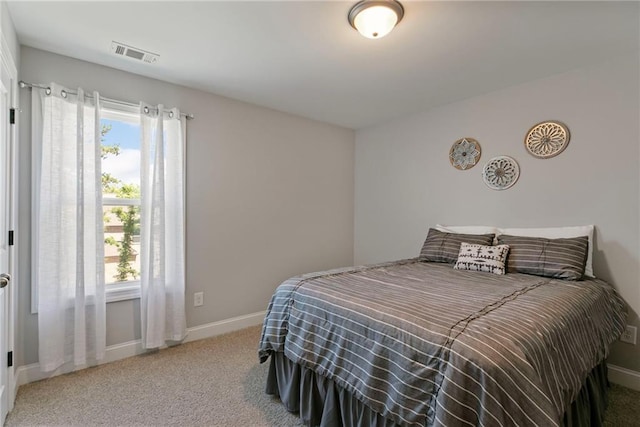 bedroom featuring multiple windows, carpet flooring, visible vents, and baseboards