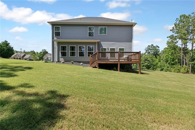 rear view of house featuring a deck and a lawn