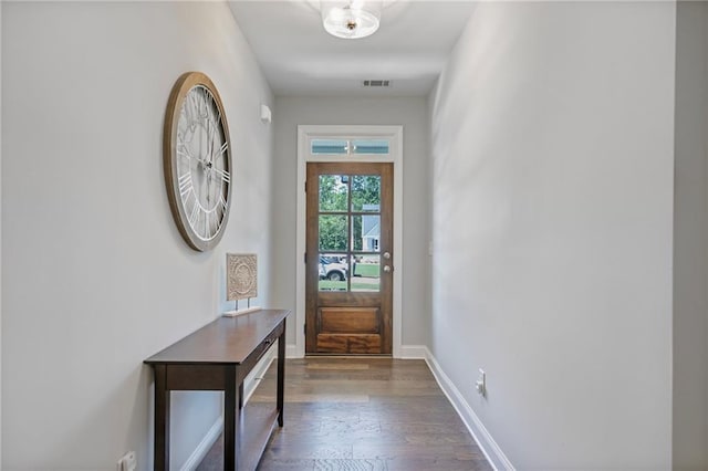 entryway with baseboards, visible vents, and wood finished floors