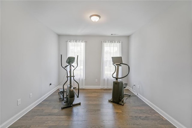 workout room featuring visible vents, baseboards, and wood finished floors