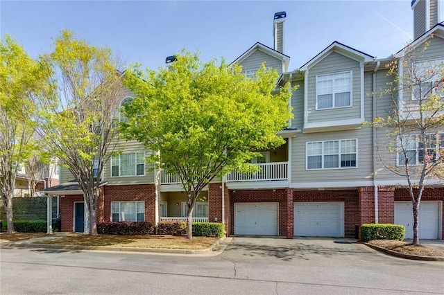 8020 Woodland Ln, Alpharetta, GA 30009 - townhome / multi-family property featuring brick siding, an attached garage, and driveway
