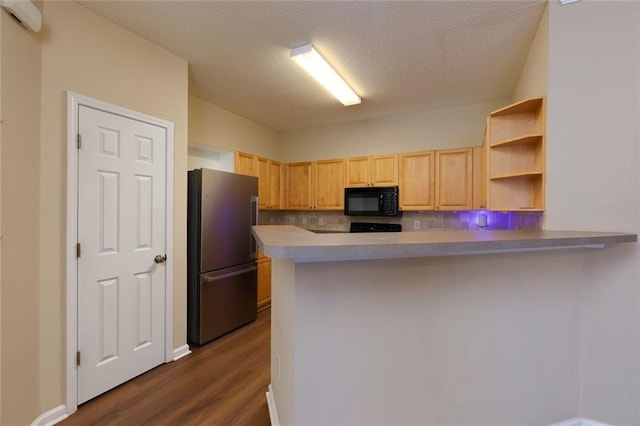 8020 Woodland Ln, Alpharetta, GA 30009 - kitchen featuring freestanding refrigerator, black microwave, light brown cabinetry, dark wood-style flooring, and a peninsula