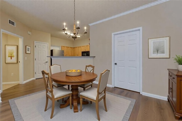 8020 Woodland Ln, Alpharetta, GA 30009 - dining area with a chandelier, dark wood finished floors, baseboards, a textured ceiling, and ornamental molding