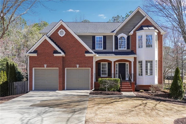 traditional-style house featuring driveway, fence, a porch, and brick siding