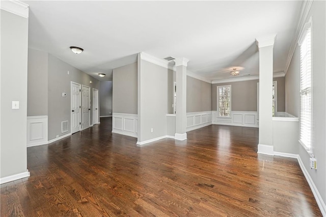 spare room featuring visible vents, a decorative wall, and wood finished floors