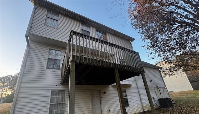 property exterior at dusk featuring central AC and a balcony