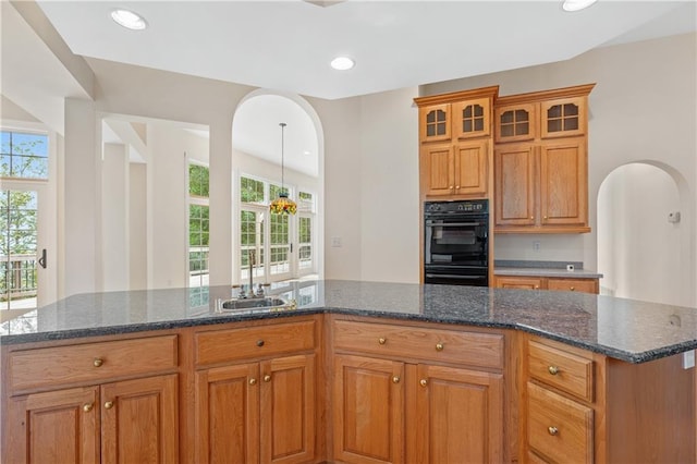 267 Starcross Ln, Jasper, GA 30143 - kitchen with a sink, brown cabinetry, arched walkways, glass insert cabinets, and recessed lighting