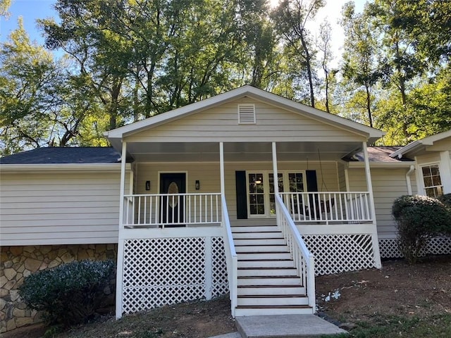 view of front of property featuring a porch, roof with shingles, and stairway