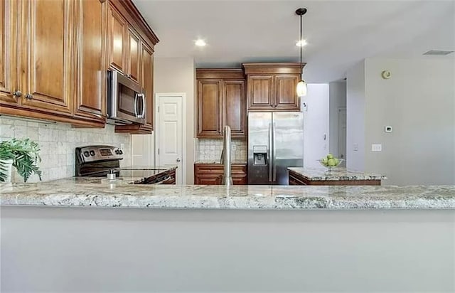 kitchen with kitchen peninsula, decorative backsplash, light stone counters, and appliances with stainless steel finishes