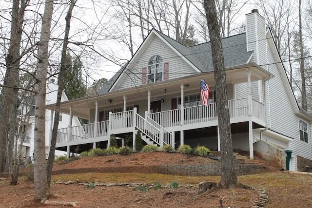 farmhouse-style home with a porch, roof with shingles, and a chimney