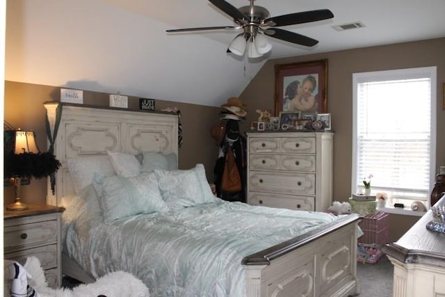 carpeted bedroom with lofted ceiling, a ceiling fan, and visible vents