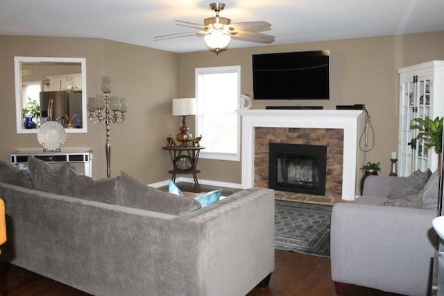 living room featuring a fireplace, dark wood-type flooring, and ceiling fan