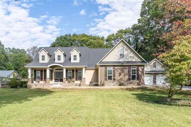 view of front of house featuring a front lawn, covered porch, and a garage