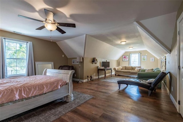 bedroom featuring ceiling fan, vaulted ceiling, multiple windows, and dark hardwood / wood-style flooring