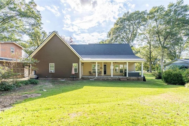 rear view of house with a porch, cooling unit, and a lawn