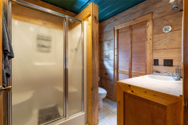 bathroom featuring vanity, toilet, wood walls, and an enclosed shower