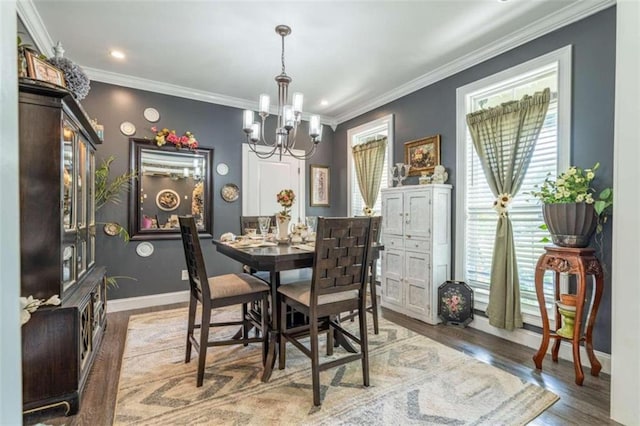 dining area featuring crown molding, wood-type flooring, and an inviting chandelier