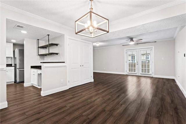 kitchen featuring a textured ceiling, stainless steel refrigerator, white cabinets, and french doors