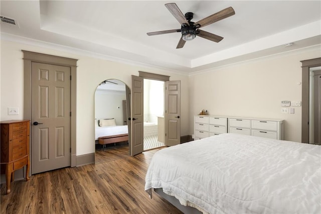 2876 White Oak Dr, Decatur, GA 30032 - bedroom with a raised ceiling, dark wood-style floors, arched walkways, crown molding, and baseboards