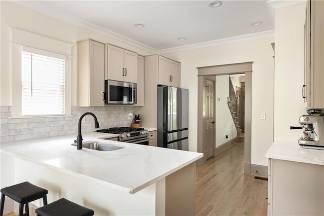 2876 White Oak Dr, Decatur, GA 30032 - kitchen with stainless steel appliances, a sink, a kitchen bar, tasteful backsplash, and a peninsula