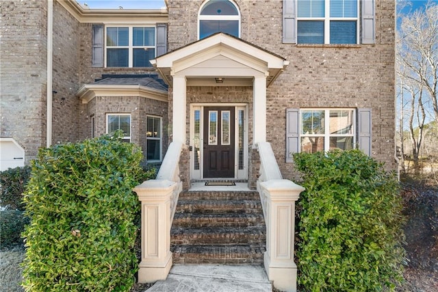 view of exterior entry featuring brick siding