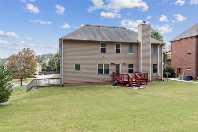 rear view of house with a wooden deck, a yard, and central AC unit