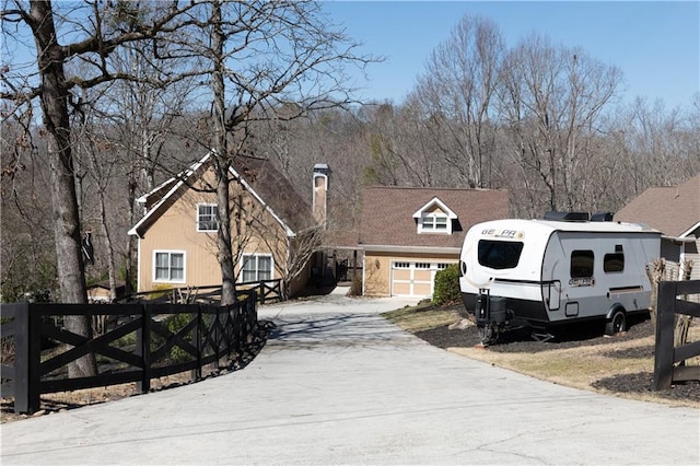 view of front of house featuring concrete driveway, fence, and a garage