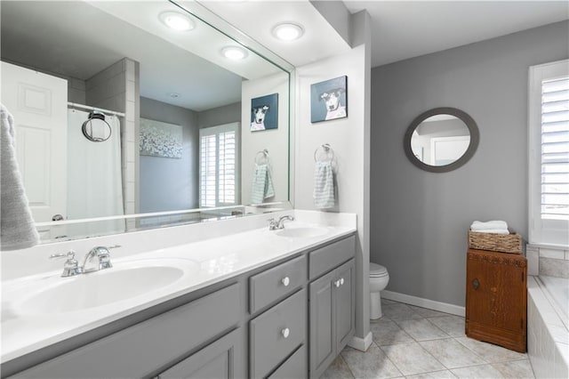 bathroom with tile patterned floors, toilet, baseboards, and a sink